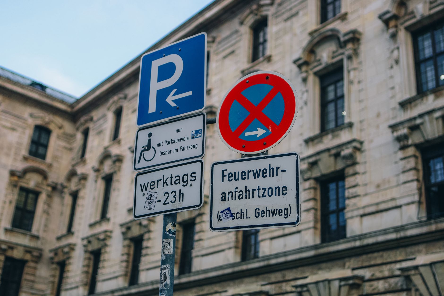 Placas de trânsito de estacionamento proibido na fachada de um prédio